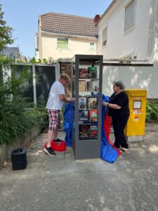 Elisabeth Bebber, Schrankpatin und Markus Politz, Schrankpate, eröffnen den Bücherschrank in Porz-Langel.